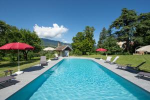 basen z leżakami i parasolami na dziedzińcu w obiekcie Domaine des Granges Longes w mieście Les Marches