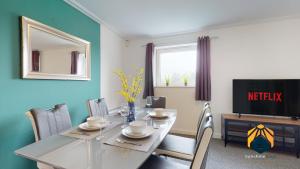 a dining room with a table and a television at Stunning Cardiff City Apartment! Sleeps 8 in Cardiff