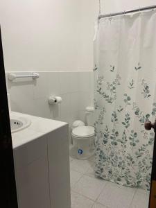 a bathroom with a toilet and a shower curtain at La Posada Manabita in Portoviejo