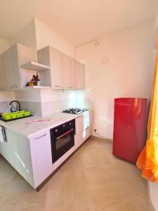 a kitchen with white cabinets and a red refrigerator at Incantevole appartamento in riva al Piave in Quero