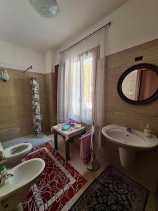 Santa Maria的住宿－Incantevole appartamento in riva al Piave，浴室设有2个水槽、浴缸和镜子