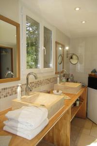 - une salle de bains avec 2 lavabos et des serviettes sur un comptoir dans l'établissement Chambre d'hôtes au temps des cerises, à Pierrefeu-du-Var