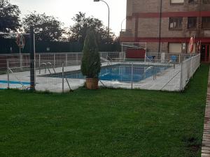 una valla alrededor de una piscina con un árbol en un patio en Apartamento Borja en Jaca