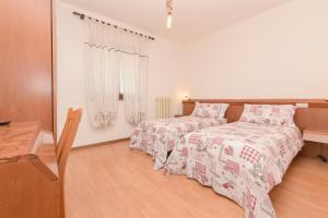 a bedroom with two beds and a wooden floor at Hotel Le Clou in Arvier