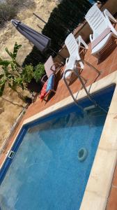 una piscina con 2 sillas y una sombrilla en Casa playa, en Segur de Calafell