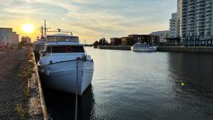 un bateau est amarré dans l'eau d'une ville dans l'établissement Houseboat Crescendo, a Floating Experience, à Oulu
