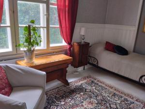 a living room with a couch and a bed and windows at Villa Anna in Lahti