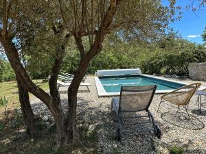 una piscina con due sedie, un tavolo e un albero di Les Terrasses de Saint-Alban a Saint Alban Auriolles