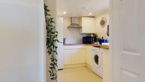 a kitchen with a washing machine and a washer and dryer at Cosy 1 bed Garden Lodge Close to Nottingham City Centre in Nottingham