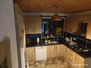 a kitchen with wooden cabinets and a sink and a window at ÇAYKARA-NANAGA 1883 Four bedroom villa in Çaykara