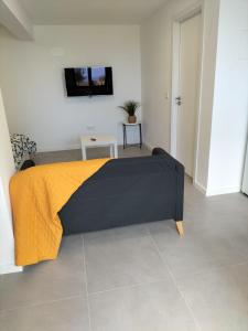 ein Schlafzimmer mit einem Bett mit einer gelben und schwarzen Decke in der Unterkunft Sun Hill Apartment in Santa Cruz