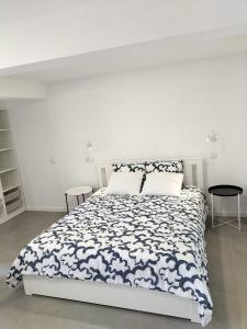 a white bedroom with a black and white bed at Sun Hill Apartment in Santa Cruz