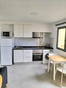 eine Küche mit weißen Geräten und einem Holztisch in der Unterkunft Sun Hill Apartment in Santa Cruz