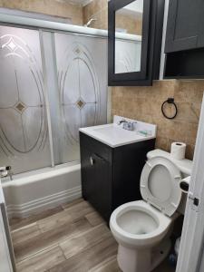 een badkamer met een toilet, een wastafel en een douche bij Granville appartment in Chicago