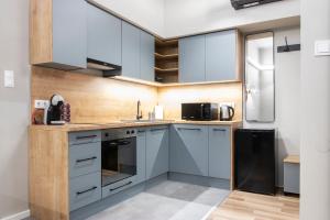 une cuisine avec des placards bleus et une fenêtre dans l'établissement Lucky 54 Apartment, à Budapest