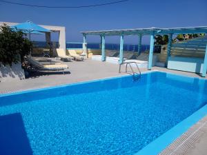 a swimming pool with a view of the ocean at Villa Anneta in Kamari