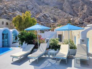 a group of chairs and umbrellas next to a pool at Villa Anneta in Kamari