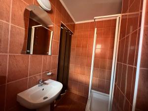 een badkamer met een wastafel, een toilet en een spiegel bij Casa Roland in Sovata