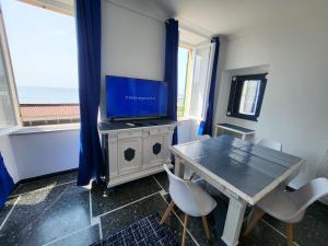 a dining room with a table and a tv at VarazzeSuite Endless Sea in Varazze