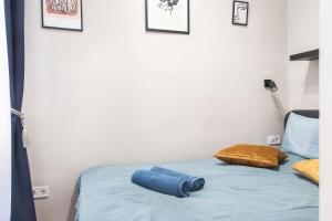 - un lit avec un drap bleu et un oreiller dans l'établissement Lucky 54 Apartment, à Budapest