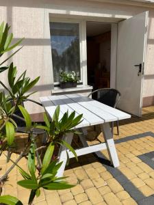 biały stół piknikowy na patio z roślinami w obiekcie Pokoje gościnne u Małgosi w mieście Jarosławiec