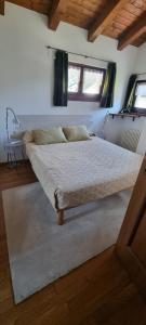 Cama grande en habitación con mesa en piccola mansarda, en Aosta