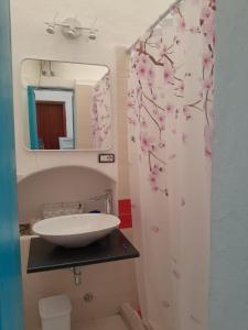baño con lavabo y cortina de ducha con flores en da Massimo, en Santa Marina Salina