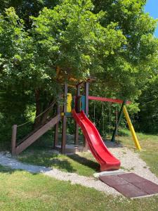 a playground with a slide in a park at Ruralna kuća za odmor Marta in Otočac