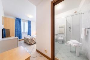 a bathroom with a shower and a toilet and a bedroom at Hotel Nuova Aurora in Marghera