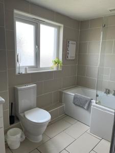 a bathroom with a toilet and a tub and a sink at Home in Buckland Brewer near Bideford in Bideford +8 photos