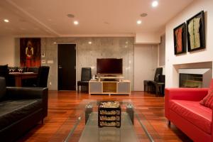 ein Wohnzimmer mit einem roten Sofa und einem TV in der Unterkunft Udelka A in Niseko