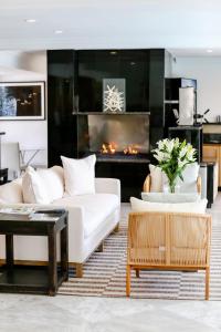 a living room with a white couch and a fireplace at Capri Laguna on the Beach - A Boutique Hotel in Laguna Beach