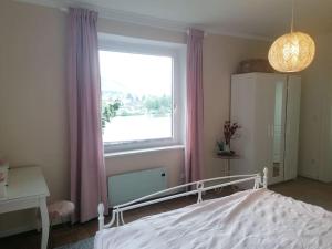 a bedroom with a bed and a large window at Voll ausgestattete Wohnung mit Moselblick in Alf