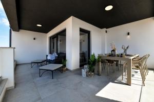 Un patio con una mesa y sillas en un edificio. en Mijatović holidays Sunset Villa Mandre min 4 nights stay, en Mandre