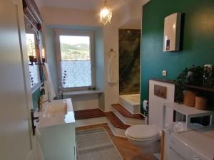 a bathroom with a white toilet and a green wall at Voll ausgestattete Wohnung mit Moselblick in Alf