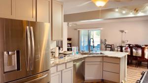 a kitchen with a stainless steel refrigerator and white cabinets at Near Disney cozy quiet place, 2 rooms with queen bed up to 4 people in Orlando