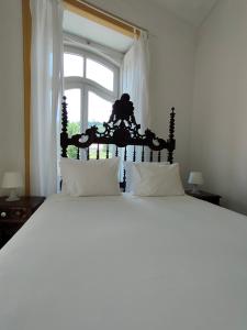 - un grand lit blanc dans une chambre avec fenêtre dans l'établissement A Vianesa - Guest House, à Viana do Castelo