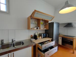 una cucina con lavandino e frigorifero di A Vianesa - Guest House a Viana do Castelo