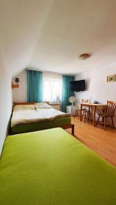 um quarto com uma cama verde e uma mesa em Pokoje u Natalii em Dziwnów