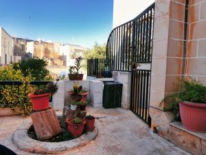 a patio with potted plants and a black fence at Double bedroom with private bathroom, NO KITCHEN in Il-Gżira