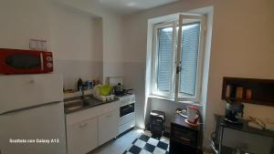 cocina con nevera, fregadero y ventana en One Love Vicino AUTOSTRADA 40 MIN ROMA, en Orte