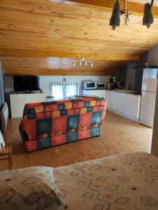 ein Wohnzimmer mit einem Sofa und einer Küche in der Unterkunft Chez Serge et Annie in Polignac