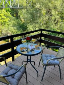 einen Tisch mit zwei Gläsern Wein und zwei Stühlen in der Unterkunft Kuća na vodi Ilma in Kulen Vakuf