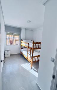 a bedroom with two bunk beds and a window at Paradise Sol Apartamento en Los Alcázares in Los Alcázares