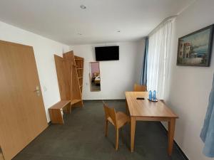 Zimmer mit einem Holztisch und einem Zimmer mit einer Tür in der Unterkunft Hotel - Ristorante La Grotta in Speyer