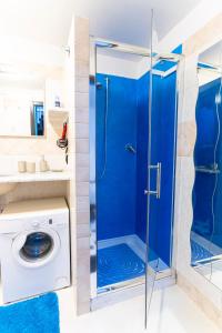 y baño con ducha azul y lavadora. en Acquario 1' Free Wifi & Netflix ''Typical Italian House'' By TILO Apartment's en Génova