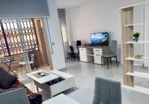 a living room with a couch and a tv in it at Paradise Sol Apartamento en Los Alcázares in Los Alcázares