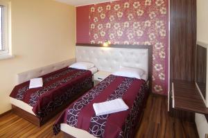 a hotel room with two beds and a wall at Kalina Family Hotel in Burgas