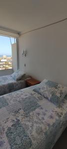 a bedroom with two beds and a window at Iquique, ED. MATIZ CAVANCHA in Iquique