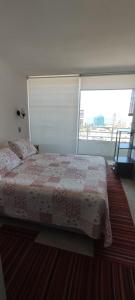 a bedroom with a bed and a large window at Iquique, ED. MATIZ CAVANCHA in Iquique